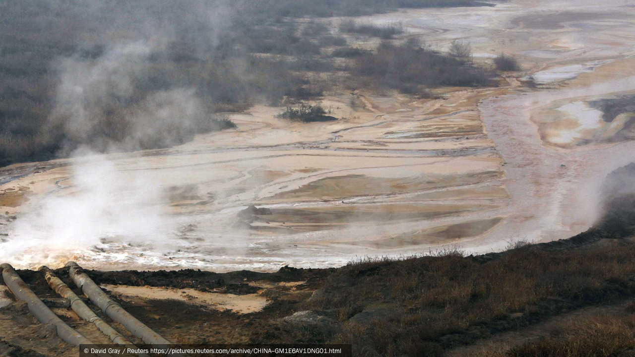 Pipes coming from a rare earth smelting plant spew polluted water into a vast tailings dam near Xinguang Village. Photograph © David Gray / Reuters